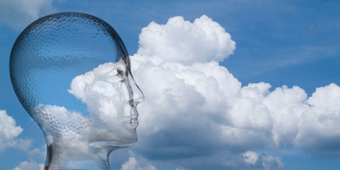 Menschenkopf aus Glas vor weißblauem Wolkenhimmel, Blickrichtung nach rechts, Textfreiraum
