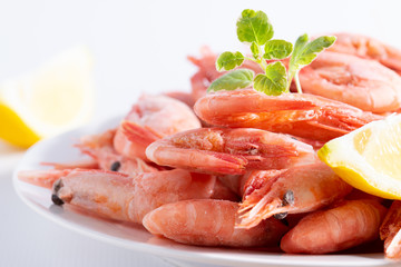 Fresh organic shrimps with lemon and aromatic herbs on the plate macro view. Sea food, healthy diet food concept.