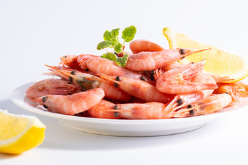 Fresh boiled shrimps with lemon and spices on dark stone background with copy space for your design. Sea food concept. Healthy diet food.