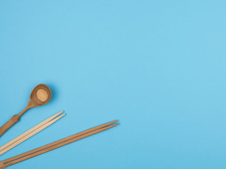 Wooden sticks for sushi and spoon on a blue background.