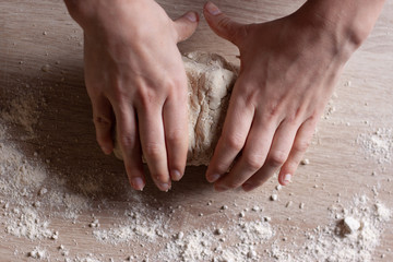 Working hands kneading bread dough