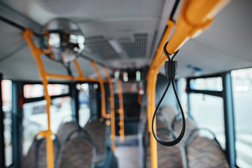 Close-up of a handle inside of empty bus during COVID-19 pandemic.