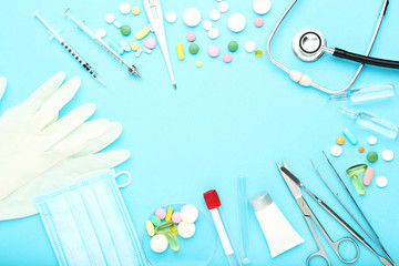 Doctor's Day concept. Medicine instruments with colorful pills on blue background