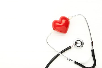 Stethoscope with red heart on white background