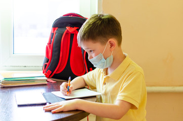 Asian child boy student in medical face mask homework online lesson at home, epidemic Coronavirus, MERS-CoV,  2019-nCoV,  quarantine, Covid-19 self-isolation, online education, home schooling