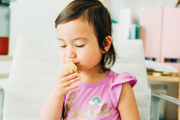 Toddler Girl Eating Banana Muffin