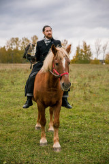 The concept of falconry. A man with a leather glove and a beautiful Falcon on handon a chestnut,...