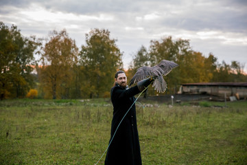 The concept of falconry. A man of European appearance with beard, with a leather glove and a...