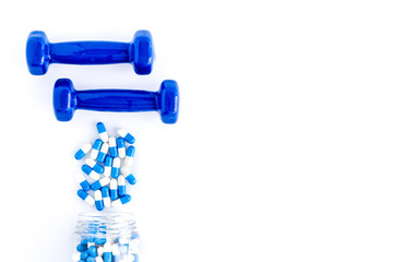 Dumbbells and creatine capsules - sport training concept - on white background top-down copy space