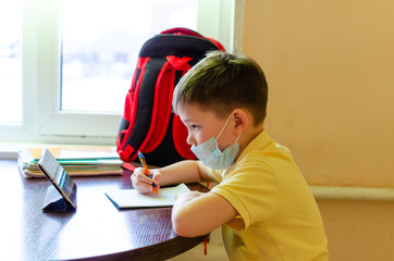Naklejka premium Asian child boy student in medical face mask homework online lesson at home, epidemic Coronavirus, MERS-CoV, 2019-nCoV, quarantine, Covid-19 self-isolation, online education, home schooling