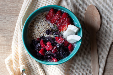 Healthy smoothie bowl with granola, fresh strawberries, blueberries, coconut, yogurt and chia seeds. Healthy food, snack or breakfast.