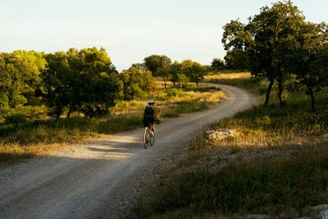 Female cyclist commutes home from work on gravel