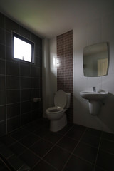 Naklejka na ściany i meble modern design of small bathroom with white lavatory water closet and used black tile wall and floor