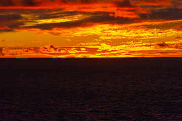 Amazing sunset with colorful clouds and dark ocean water, nature background