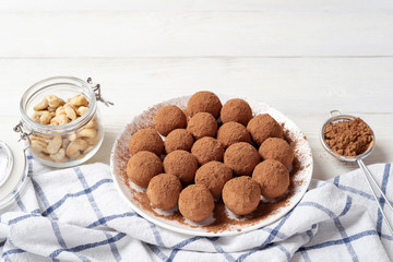 Vegan energy balls with dates, cashew and cocoa. White wooden background. Good nutrition concept. Raw food.