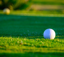 Excellent well-kept green grass lawn on large golf course, green section with big white foam ball for beginners on Tenerife island, Canary, Spain