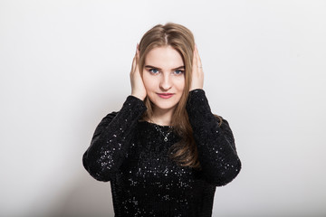 portrait of a blond woman closing her ears due to noise in her head