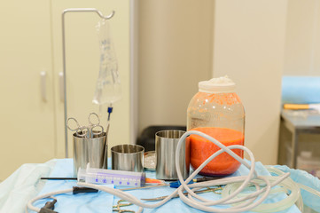 Bottle of liquid fat from liposuction. Slimming through plastic surgery. The figure of a dream.