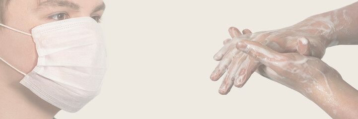 Fototapeta premium Corona virus. Young guy in a medical protective mask and washing his hands with soap on a white background. Protection against viruses, infections.