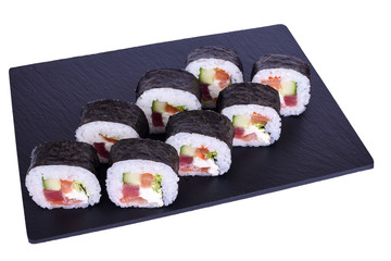 Traditional fresh japanese sushi Futomaki maki on black stone Maki Daikon on a white background. Roll ingredients: radish daikon, nori, rice.