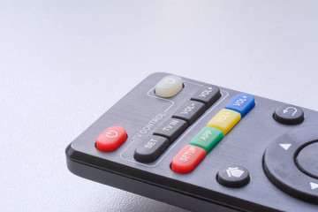 Black remote control on white background closeup with copyspace.