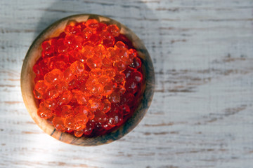 Red vegan caviar from kelp seaweed in a wooden bowl on a white background. Valuable and useful product for a healthy diet. Superfood. Close-up