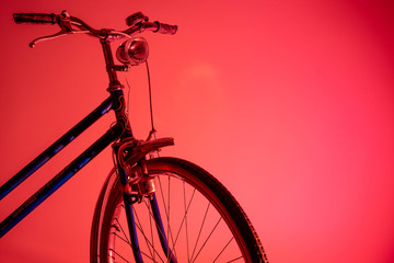 Old bicycle in shadow with isolated front light in colored background. Old bike concept