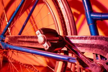 Close up view of an old isolated bicycle pedal on a background illuminated with coloured lights. Vintage concept