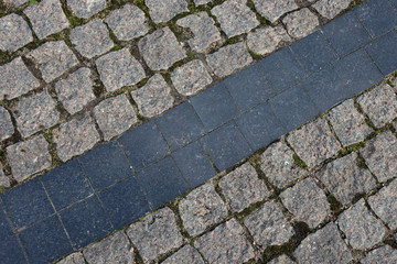 The road in Rome. Antique road. A road made of square gray stones and a blue stripe in the middle