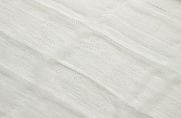 Fototapeta na wymiar white color woven cotton gauze fabric background texture. close up top view. Selective soft focus. Shallow depth of field. Text copy space.