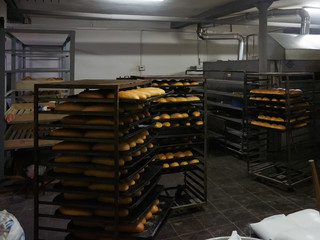 Baking tray with tasty bread, indoors. Pallets with freshly baked bread. Industrial production of bread in the bakery