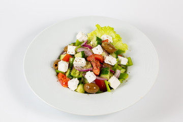 Greek salad on a plate on a white background