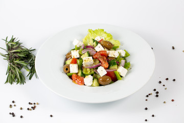 Greek salad on a plate on a white background