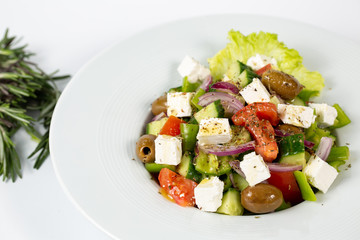 Greek salad on a plate on a white background