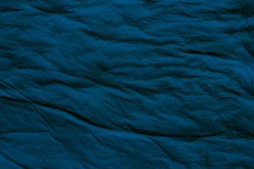 Texture of a gently dark blue crumpled surface. Crumpled Blue Background