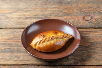 plate with fresh hot mini pie on wooden table, close view 