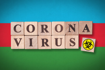 Azerbaijan flag background and wooden blocks with letters spelling CORONAVIRUS and quarantine symbol on it. Novel Coronavirus (2019-nCoV) concept, for an outbreak occurs in Azerbaijan.