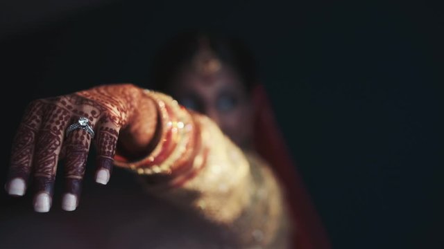 Front View of hand with engagement ring of indian bride painted with henna ornament in traditional clothes, wedding day