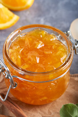 Homemade orange jam in jar on a gray table. Food background Copy space