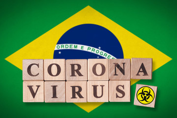 Brazil flag background and wooden blocks with letters spelling CORONAVIRUS and quarantine symbol on it. Novel Coronavirus (2019-nCoV) concept, for an outbreak occurs in Brazil.