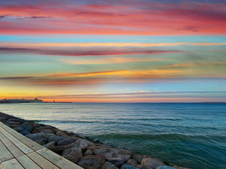Sea sunset colorful evening sky and moon on cloudy  skyline,  light reflection on seawater, gold summer city  in   Tallinn old town panorama on beach  horizon ,nature background Estonia Baltic sea