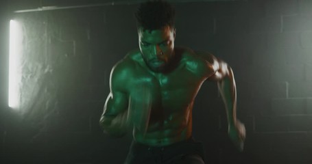 Man doing agility workout in dark gym