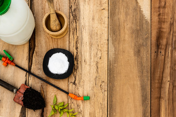 Garden care topic: Manual sprayer, fertile black soil, shovel, and mortar to make homemade...