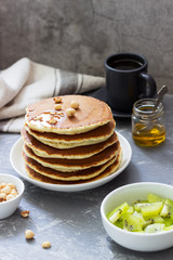 Vegetarian breakfast of pancakes, coffee, honey, nuts and fruits.