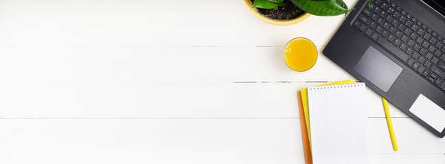 Online education or learning concept top view. Work at home. Remote work. Laptop, books on a white wooden background. Copy space