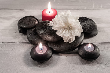 Galets noirs avec gouttes d'eau et bougies.