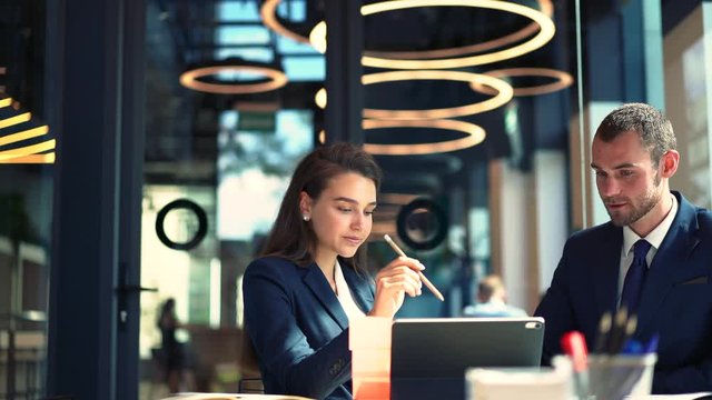 Successful colleagues analyzing information from financial website connected to 4g wireless on modern touch pad, confident corporate directors discussing business strategy indoors