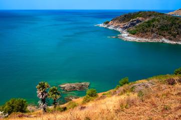 View of the sea, blue sky and palm trees at Promthep Cape in Phuket, southern Thailand.