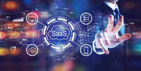SaaS - software as a service concept with businessman on night city background