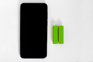 A smartphone battery capacity concept. A mobile phone and two green batteries on the white background